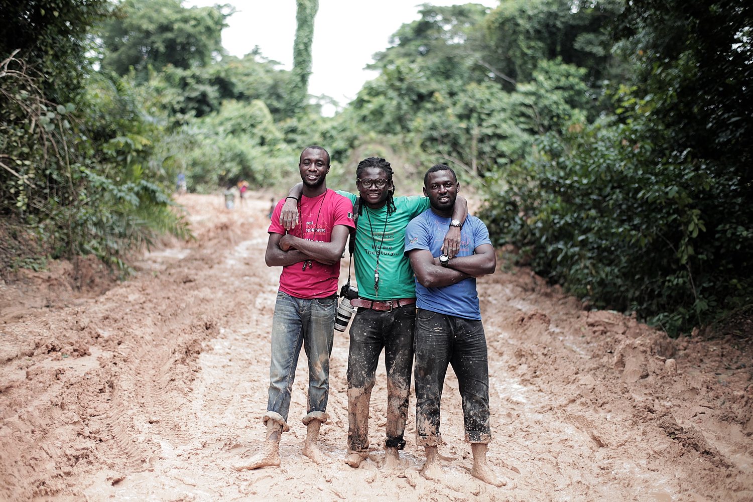 Three participants standing barefoot on a deeply rutted forest road